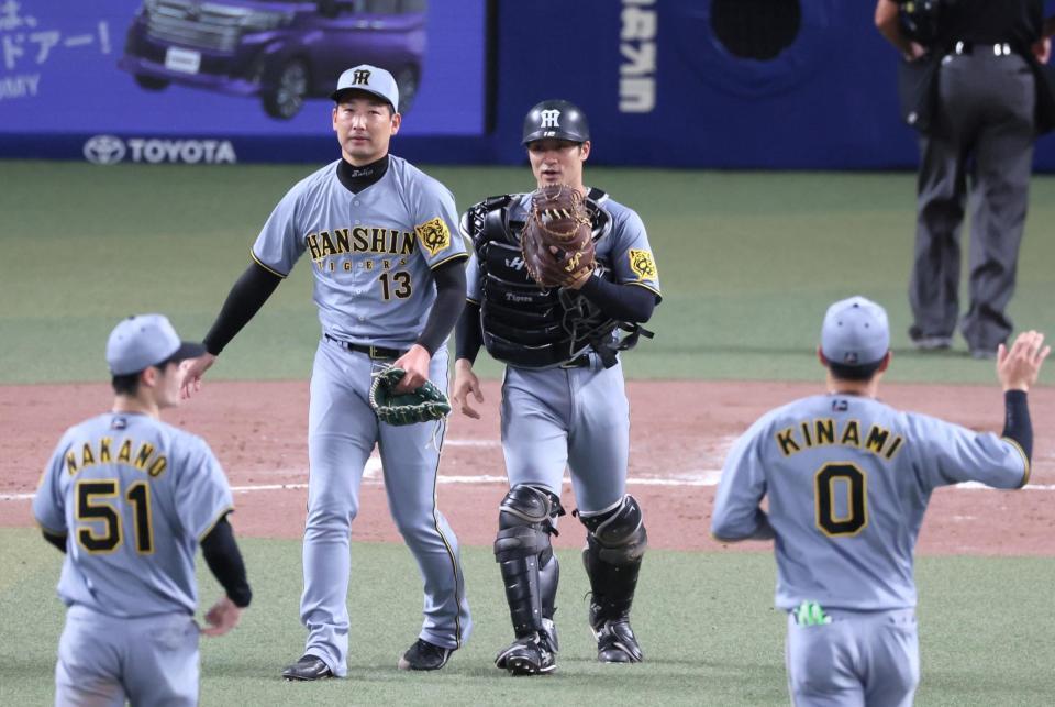 　９回を締めくくった岩崎（中央左）とマウンドへ向かう坂本（同右）＝撮影・立川洋一郎