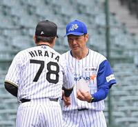 　平田２軍監督（左）とメンバー表の交換をする石川・岡崎太一監督（撮影・西田忠信）