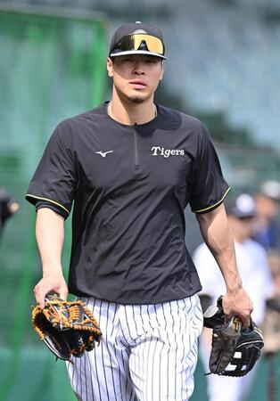 　２種類のグラブを手にする佐藤輝（撮影・西田忠信）