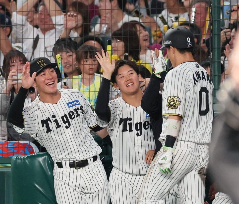 　５回、近本の先制適時打で生還した木浪（０）を迎える門別（中央）＝撮影・北村雅宏