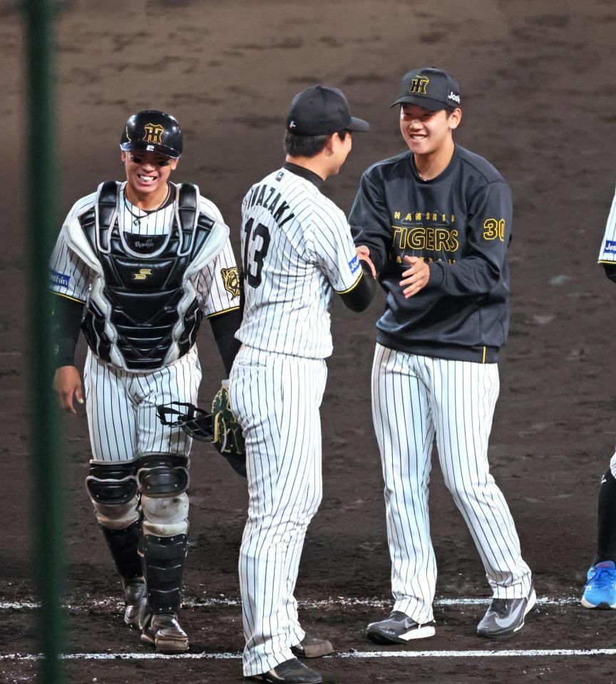 　２勝目を挙げ、岩崎（中央）と笑顔で握手を交わす門別。左は梅野（撮影・立川洋一郎）