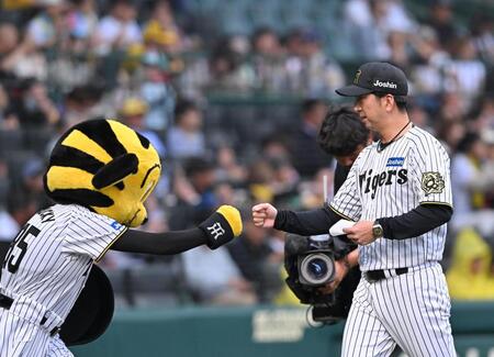 　メンバー表の交換を終え、ベンチ前でトラッキーとグータッチする藤川監督（撮影・西田忠信）