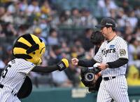 　メンバー表の交換を終え、ベンチ前でトラッキーとグータッチする藤川監督（撮影・西田忠信）