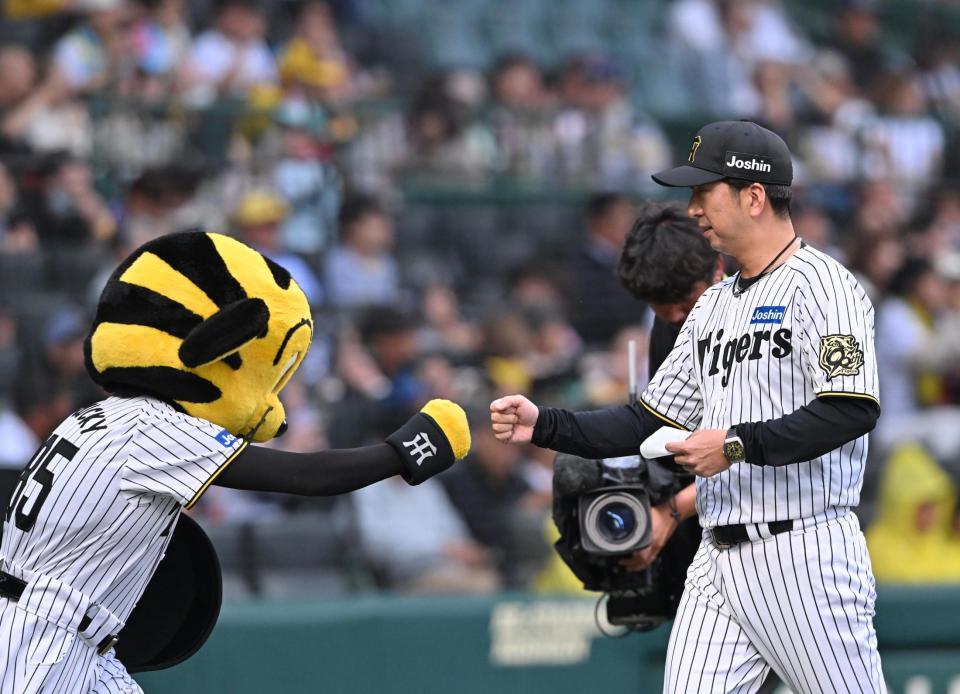 　メンバー表の交換を終え、ベンチ前でトラッキーとグータッチする藤川監督（撮影・西田忠信）