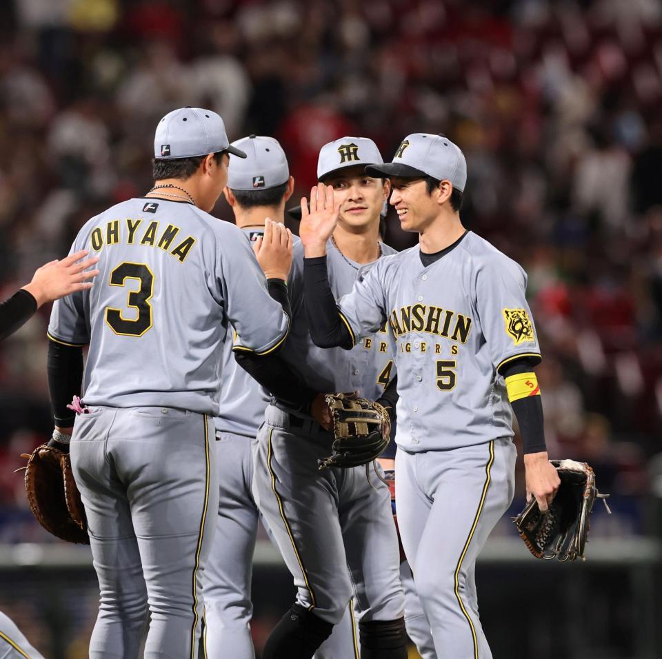 　試合を終え、ナインと笑顔でタッチを交わす近本（撮影・市尻達拡）