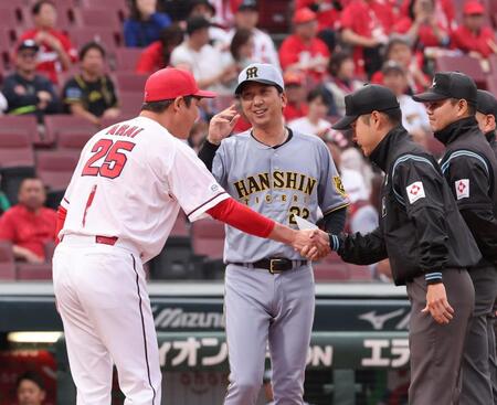 　笑顔でメンバー表の交換をする新井監督と藤川監督（撮影・市尻達拡）