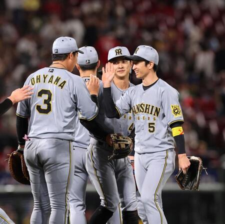 　試合を終え、ナインと笑顔でタッチを交わす近本（撮影・市尻達拡）