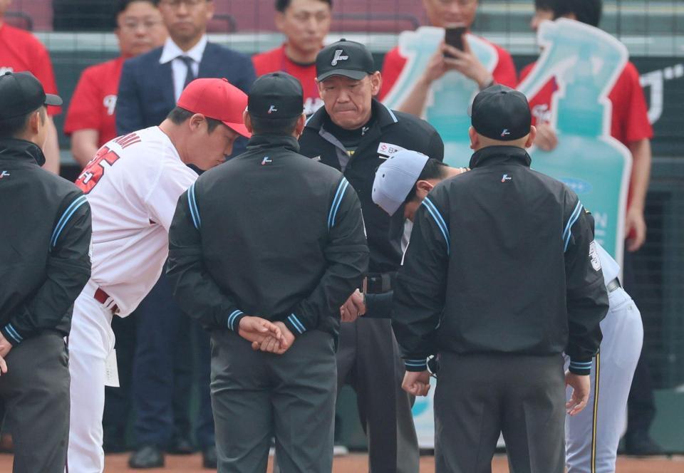 　メンバー表交換を終え、握手する藤川監督と新井監督（左から２人目）＝撮影・北村雅宏