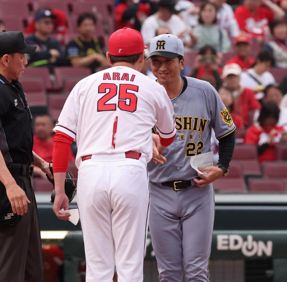 　笑顔で新井監督と握手をする藤川監督（撮影・市尻達拡）