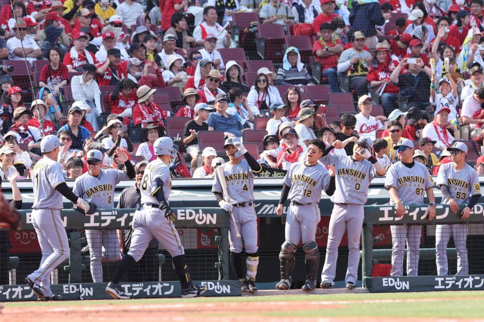 　８回、生還した佐藤輝と森下を出迎える阪神ナイン（撮影・市尻達拡）