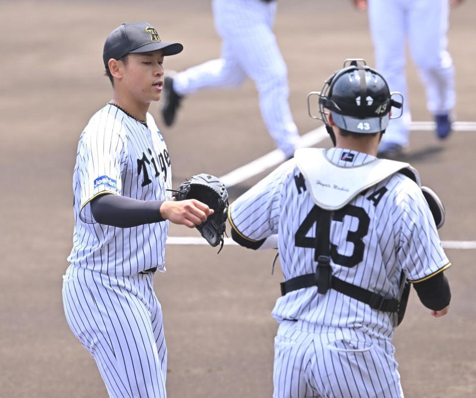 　初回を三者凡退で終え、町田（右）とタッチを交わす早川（撮影・西田忠信）