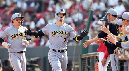 　８回、３ランを放ち、ナインに迎えられる佐藤輝。左は森下（撮影・田中太一）