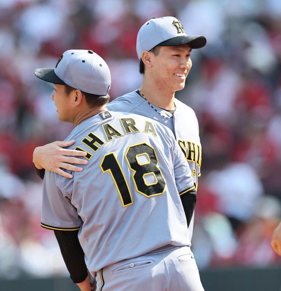 　７回、伊原（手前）のピンチを救った湯浅は肩を抱きながらベンチへ戻る（撮影・田中太一）