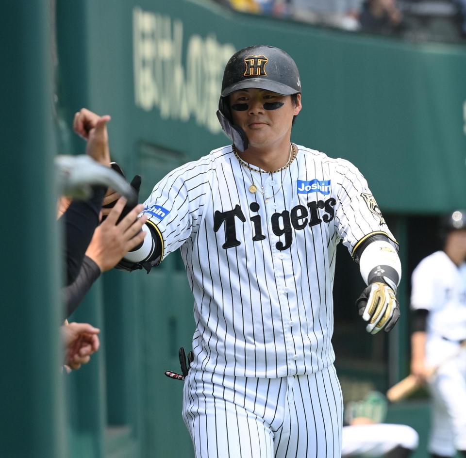 　１回、先制ソロを放ちベンチ前でナインとタッチを交わす前川（撮影・西田忠信）