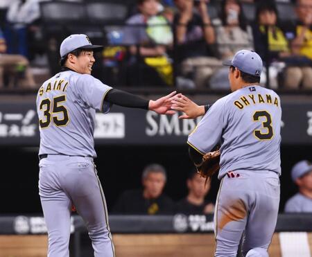 　６回、打者レイエスを遊ゴロに抑え、大山（右）とタッチを交わす才木（撮影・中島達哉）