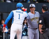 メンバー表を交換し、新庄監督（左）とグータッチを交わす藤川監督（撮影・中島達哉）