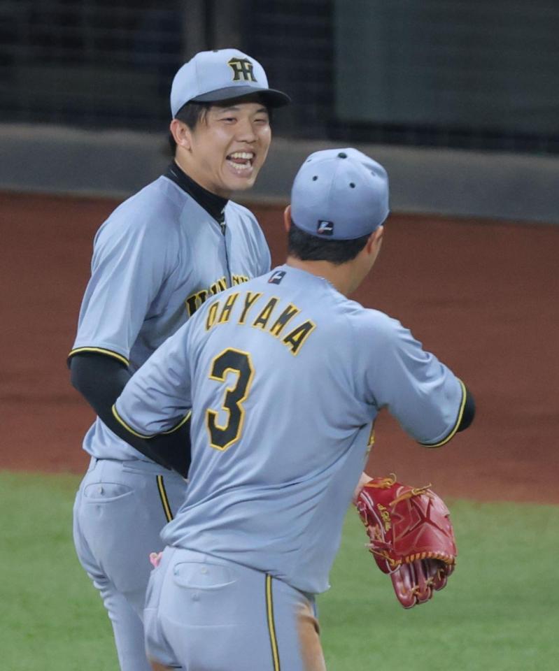 　６回、ピンチをしのぎ、大山（右）と笑顔でタッチする才木（撮影・西岡正）