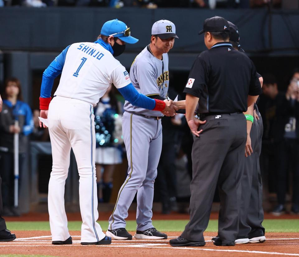 　メンバー表を交換し、審判団と握手を交わす新庄監督（左）と藤川監督（中央）＝撮影・中島達哉