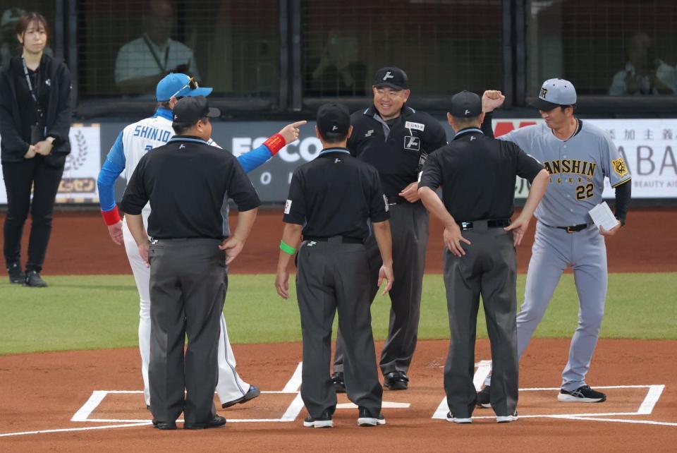 メンバー表交換で健闘を誓う新庄監督（左）と藤川監督（右）＝撮影・西岡正