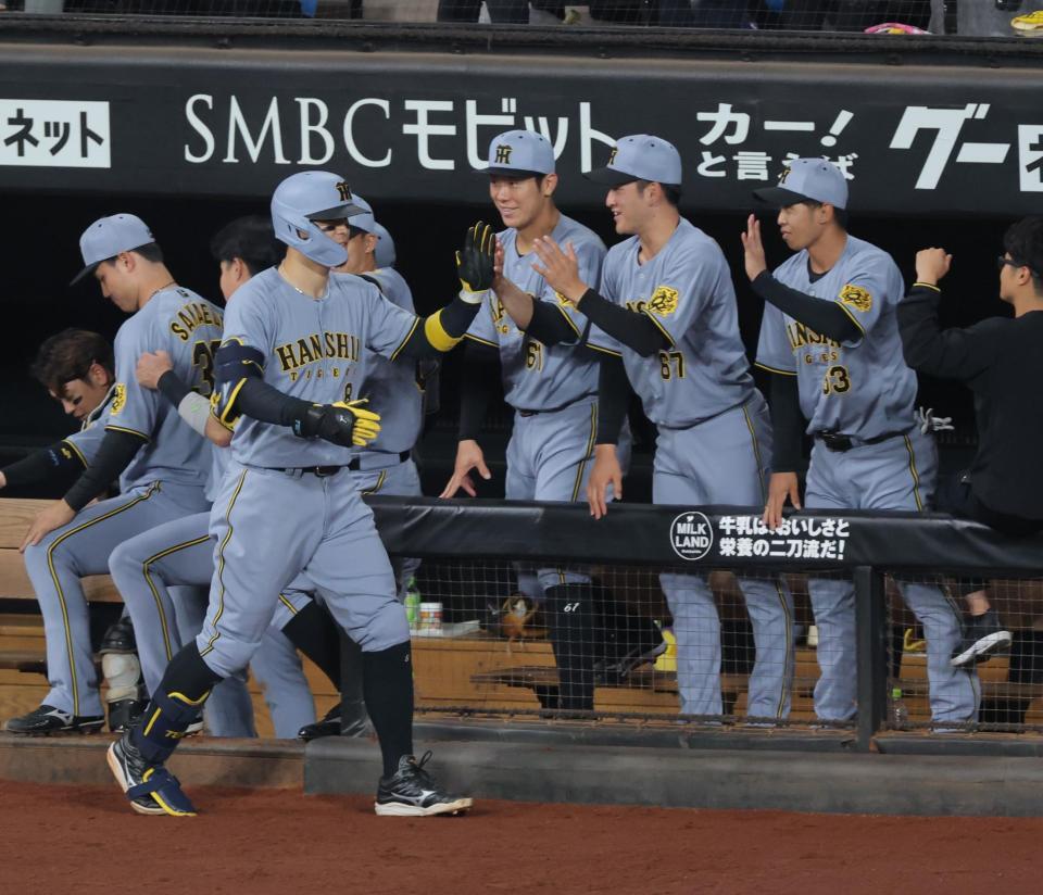 ４回、ソロを放ち、ナインに迎えられる佐藤輝（撮影・西岡正）