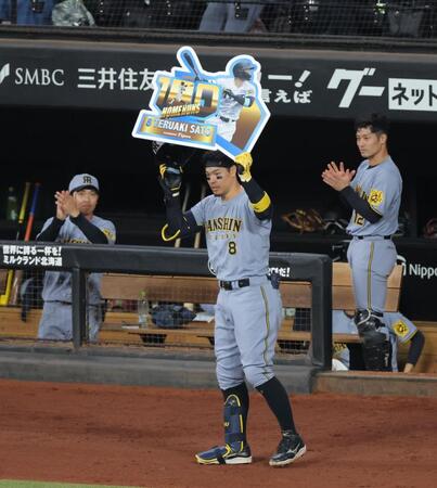 　８回、通算１００号を放ち、ボードを掲げる佐藤輝（撮影・西岡正）