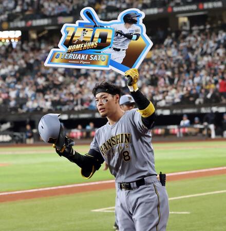 　８回、プロ通算１００号本塁打を放った佐藤輝はボードを掲げる（撮影・田中太一）