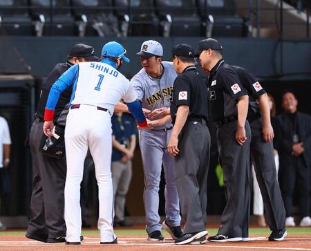 　メンバー表を交換し、新庄監督（左から２人目）、審判団と手を合わせる藤川監督（中央）＝撮影・中島達哉