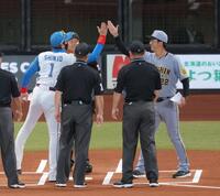 　メンバー表交換で新庄監督（左）、審判団と手を合わせた後、ハイタッチする藤川監督（撮影・西岡正）