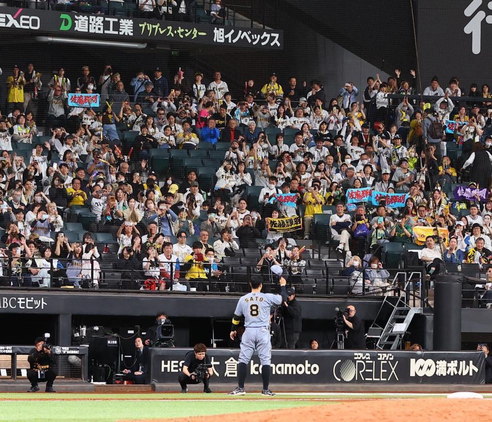 　ヒーローインタビューを終え、スタンドのファンの歓声に応える佐藤輝（撮影・中島達哉）