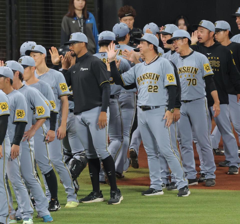 　デュプランティエ（中央左）と並んでナインを迎える藤川監督（同右）＝撮影・西岡正