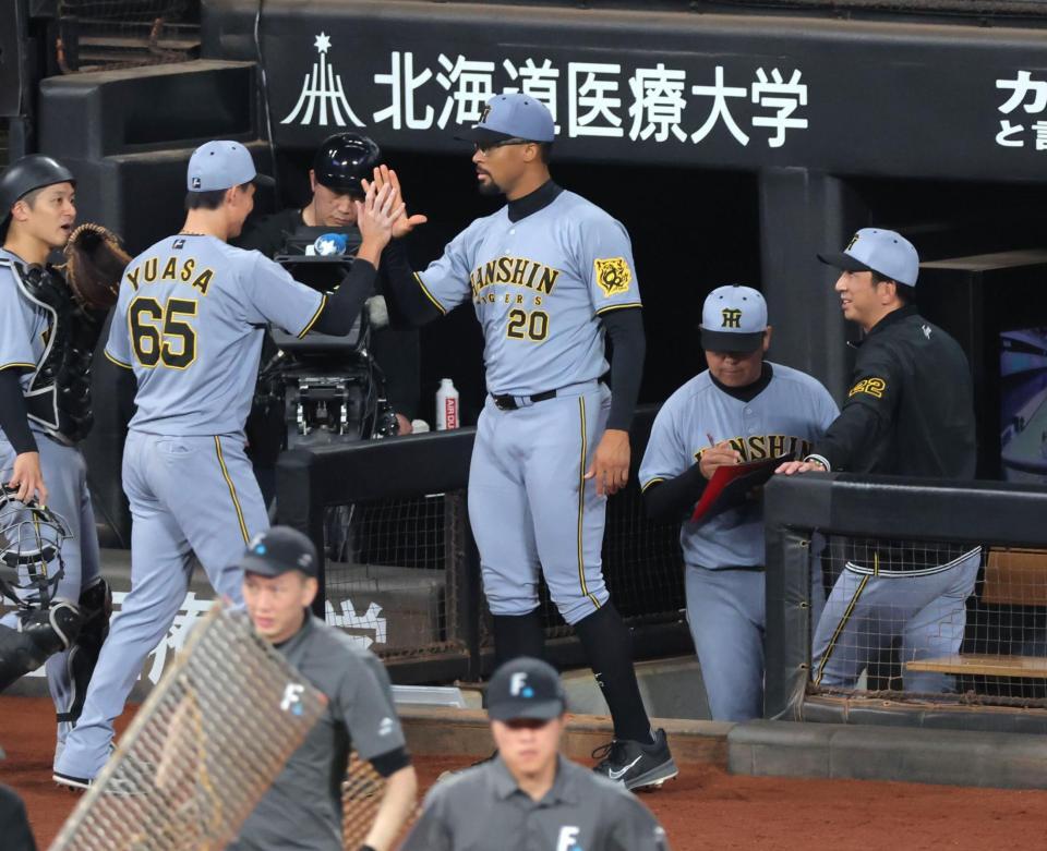 　７回、ピンチを救った湯浅（左）を迎えるデュプランティエ（右は藤川監督）＝撮影・西岡正