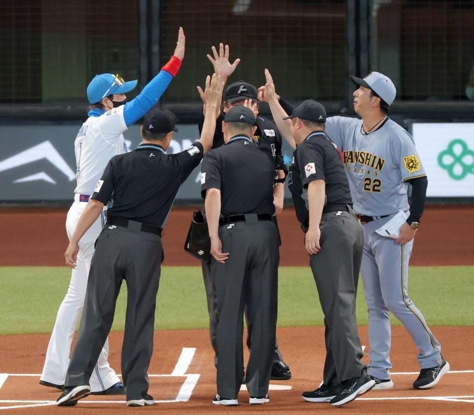 　メンバー表交換でかけ声とともに手を上げる両監督と審判団（撮影・西岡正）
