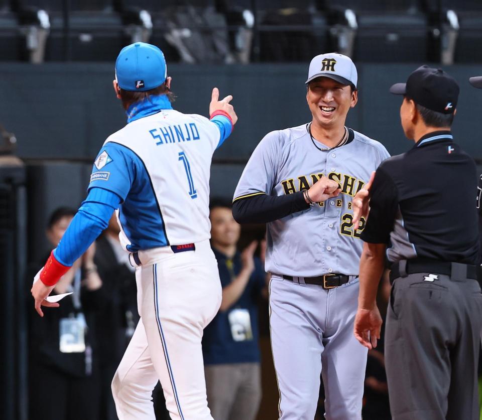 　新庄監督（左）とのメンバー表交換を終え、笑顔を見せる藤川監督（中央）＝撮影・中島達哉