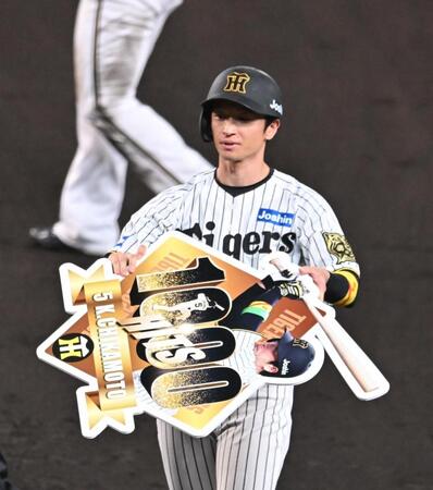 　７回、通算１０００安打を達成し、記念ボードを手にする近本（撮影・西田忠信）