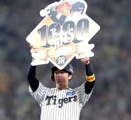 　７回、公式戦通算１０００安打を達成し、記念のボードを掲げる近本（撮影・北村雅宏）