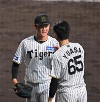 　７回、頓宮を三振に仕留めベンチ前で湯浅（右）に迎えられる及川（撮影・西田忠信）