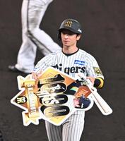 　７回、通算１０００安打を達成し、記念ボードを手にする近本（撮影・西田忠信）