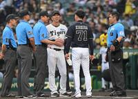 　審判団から説明を受け、笑顔でメンバー表交換する藤川監督と岸田監督（撮影・飯室逸平）