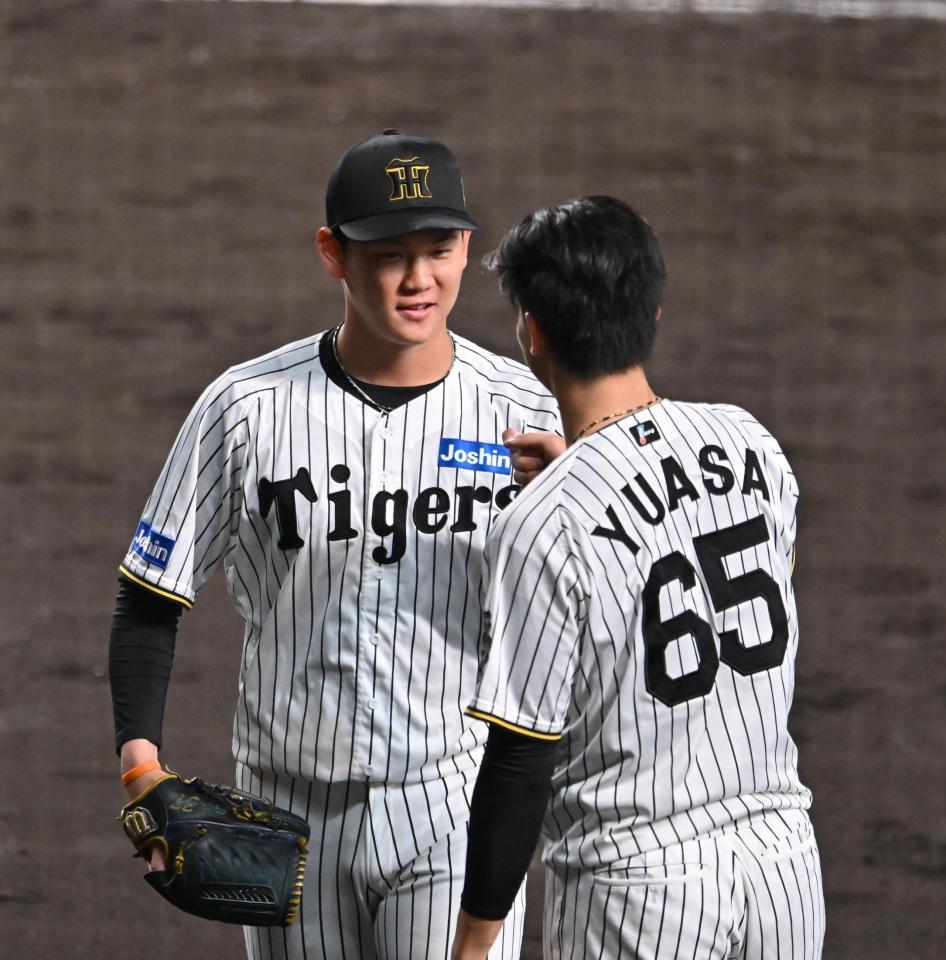 　７回、頓宮を三振に仕留めベンチ前で湯浅（右）に迎えられる及川（撮影・西田忠信）