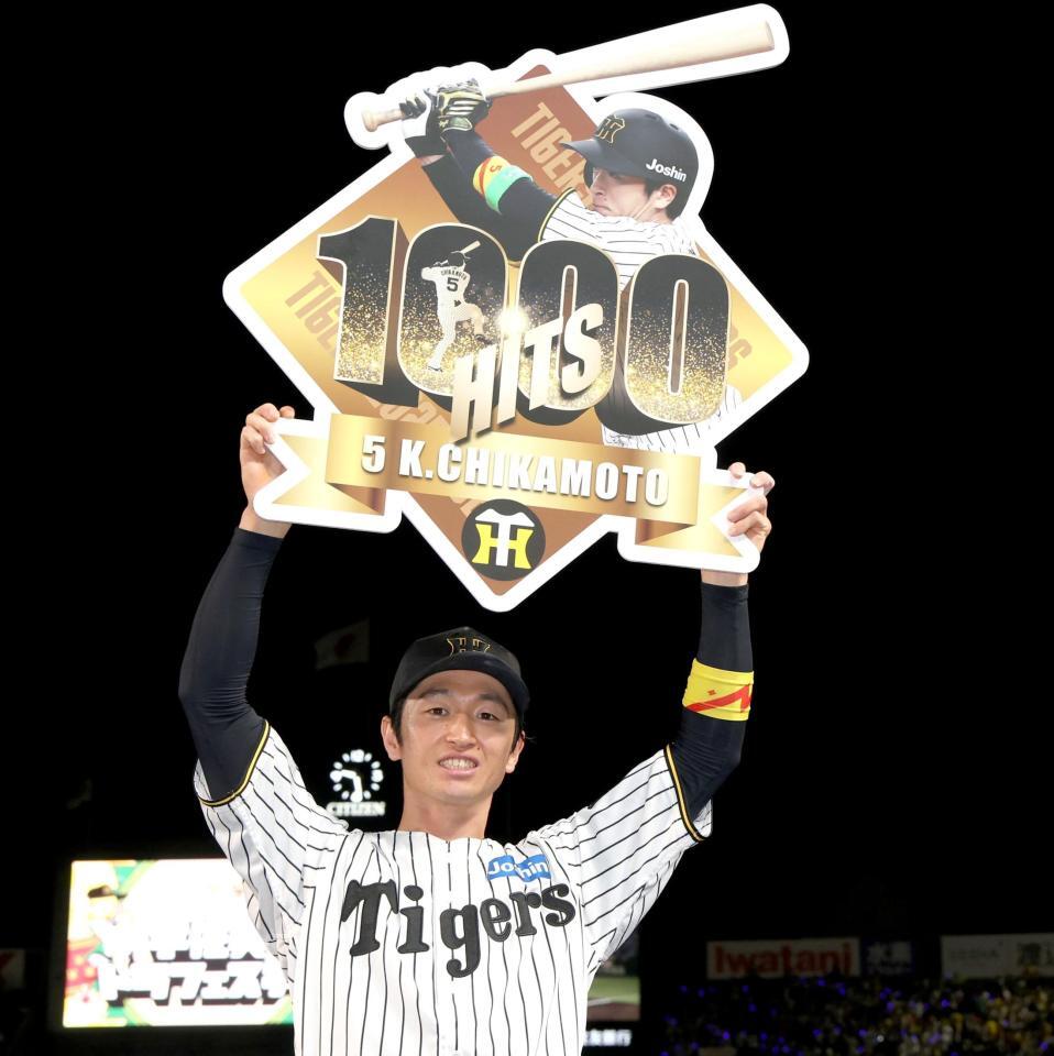 　公式戦通算１０００安打を達成し、記念のボードを掲げる近本（撮影・北村雅宏）