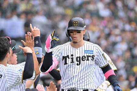 　８回、満塁本塁打を放ちナインに迎えられる佐藤輝（撮影・西田忠信）