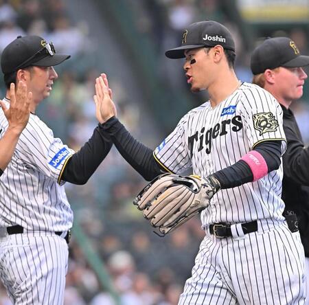 　オリックスに勝利し、藤川監督（左）とタッチを交わす佐藤輝（撮影・西田忠信）