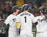 　６回、声を張り上げ森下（１）を迎える近本（撮影・飯室逸平）