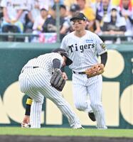 　４回、頓宮の中前打の処理にもたつく近本（手前）＝撮影・西田忠信