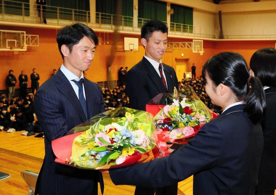 　社高校の激励会で後輩から花束を受け取る近本（左）と辰己＝１８年１２月１８日
