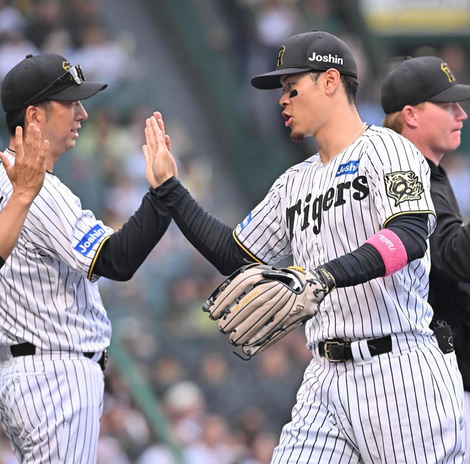 　オリックスに勝利し、藤川監督（左）とタッチを交わす佐藤輝（撮影・西田忠信）