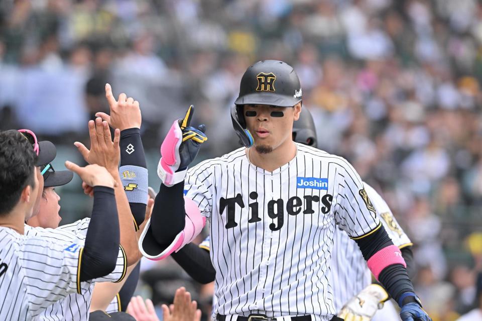 　８回、満塁本塁打を放ちナインに迎えられる佐藤輝（撮影・西田忠信）