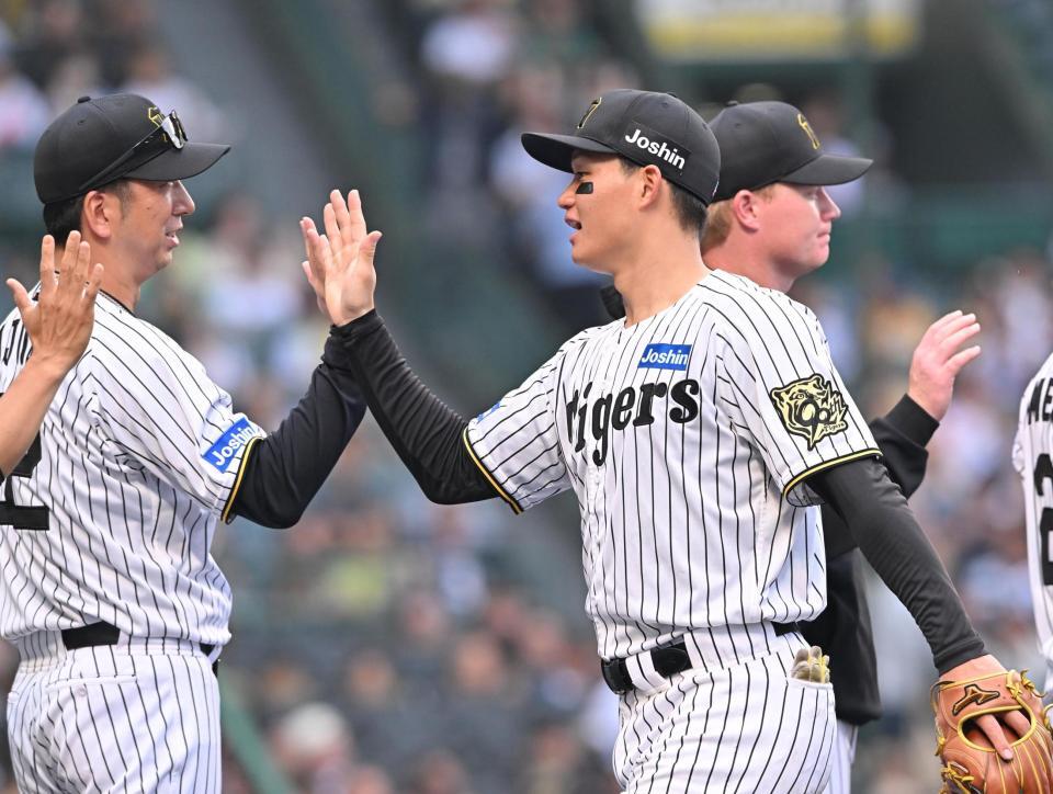 　オリックスに勝利し、藤川監督（左）とタッチを交わす森下（撮影・西田忠信）