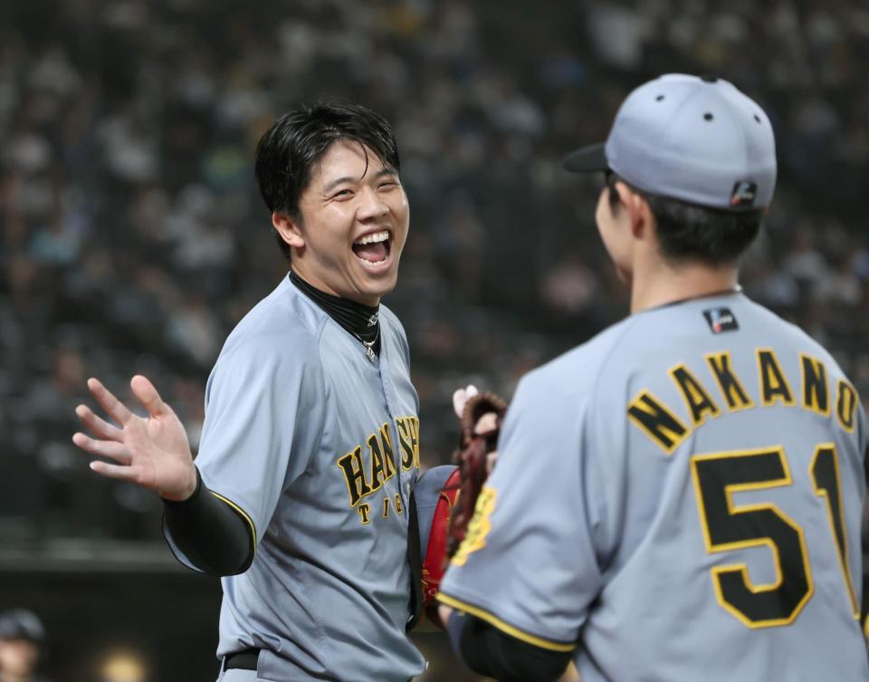 ６回、満塁のピンチで源田を二邪飛に打ち取り、好捕した中野と笑顔でタッチをかわす才木（撮影・田中太一）