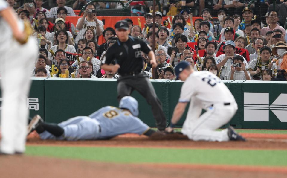 　８回、けん制球でタッチアウトになる一走の佐藤輝。一塁手はネビン（撮影・堀内翔）